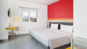 A hotel room with a bed, a desk, a chair, a TV, and a window with a city view. - Amaris Hotel Setiabudhi (Bandung)