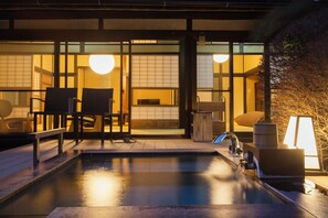 A traditional Japanese-style building with a pool, seating area, and a wooden structure. - Ito Ryokuyu (Ito)