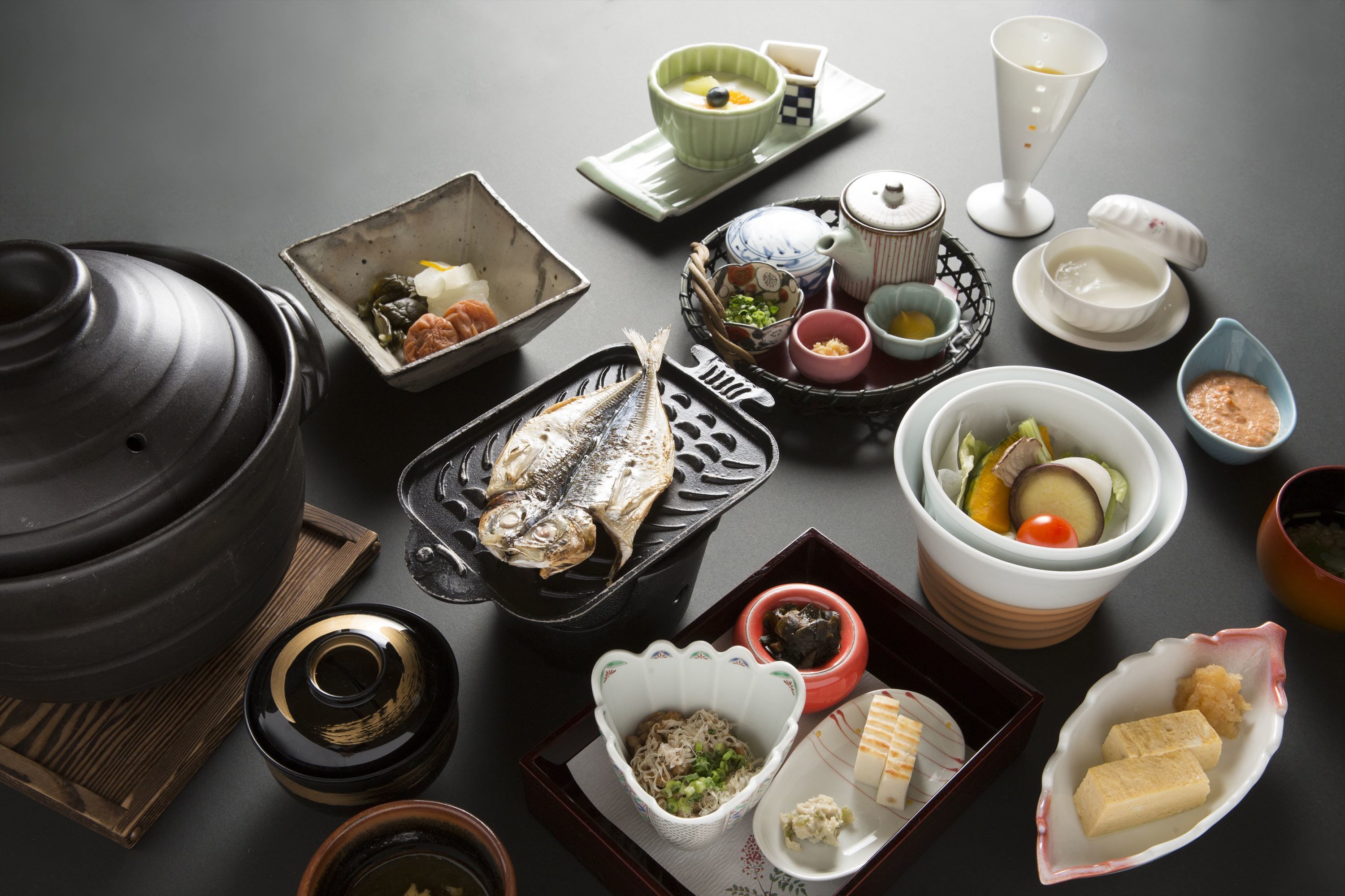 Verschiedene japanische Gerichte und Besteck sind auf einem Tisch angerichtet.