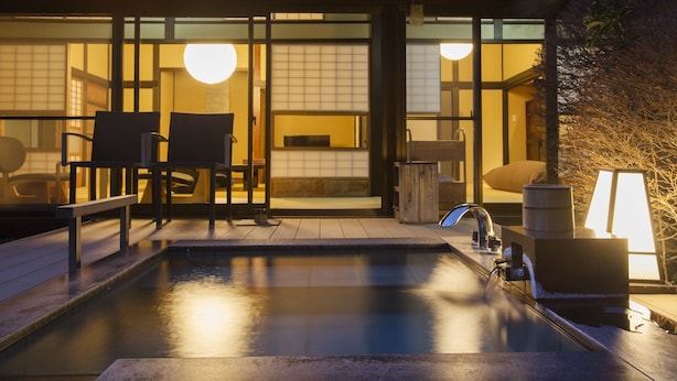 En traditionel japansk bygning med pool, opholdsområde og en trækonstruktion.
