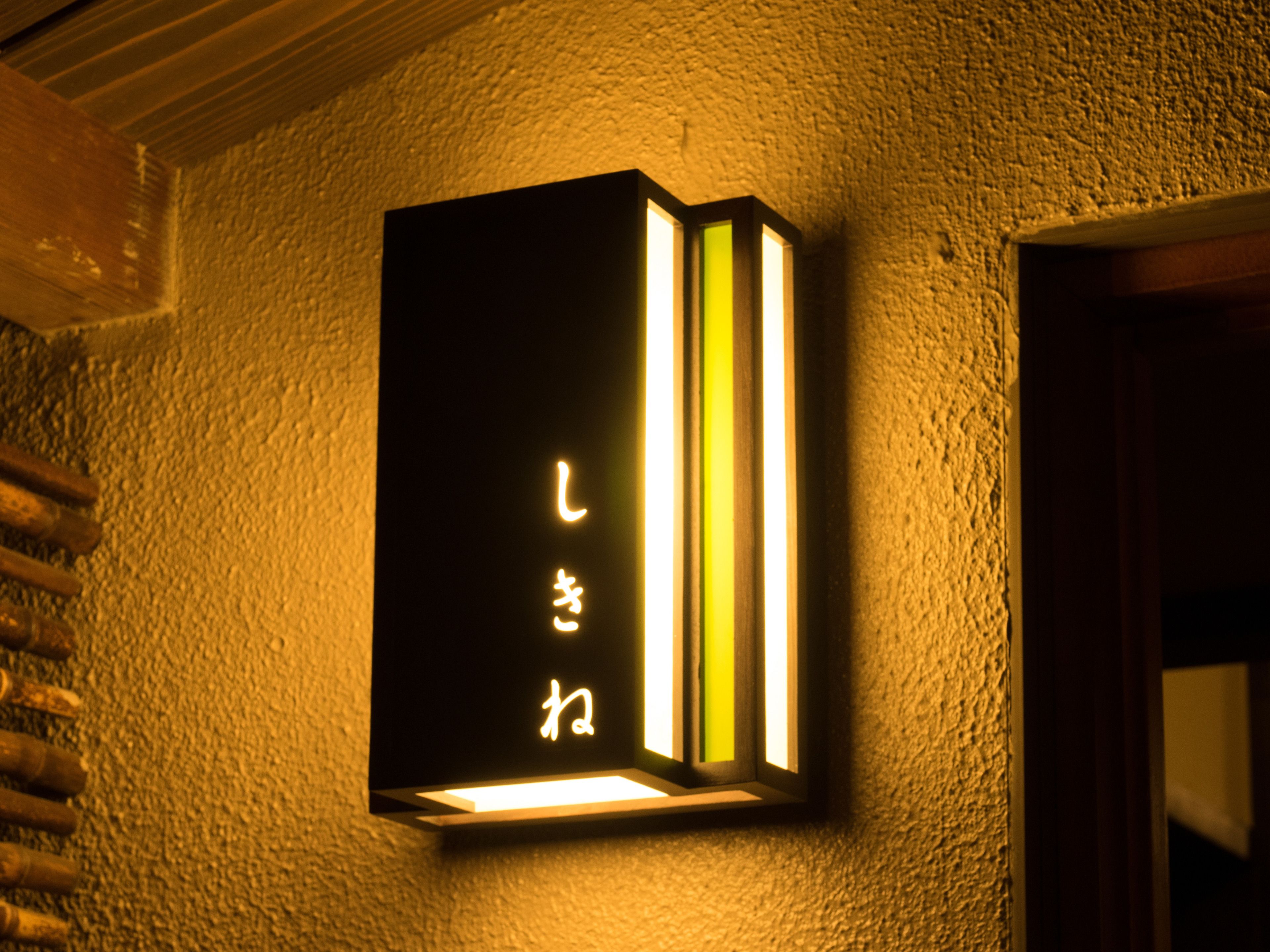 A wall-mounted light fixture with Japanese characters.