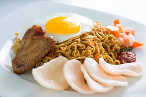 Een bord eten met noedels, een gebakken ei, plakjes vlees en groenten.