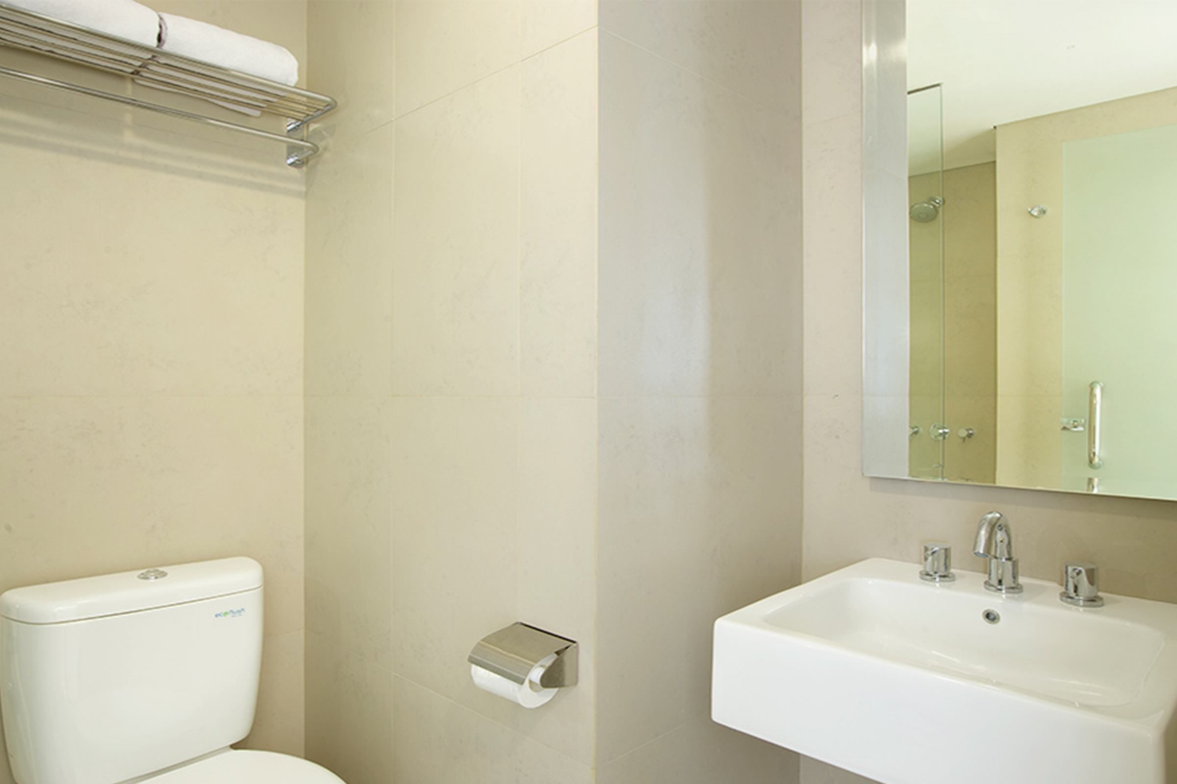 Un baño con inodoro, lavabo y espejo.