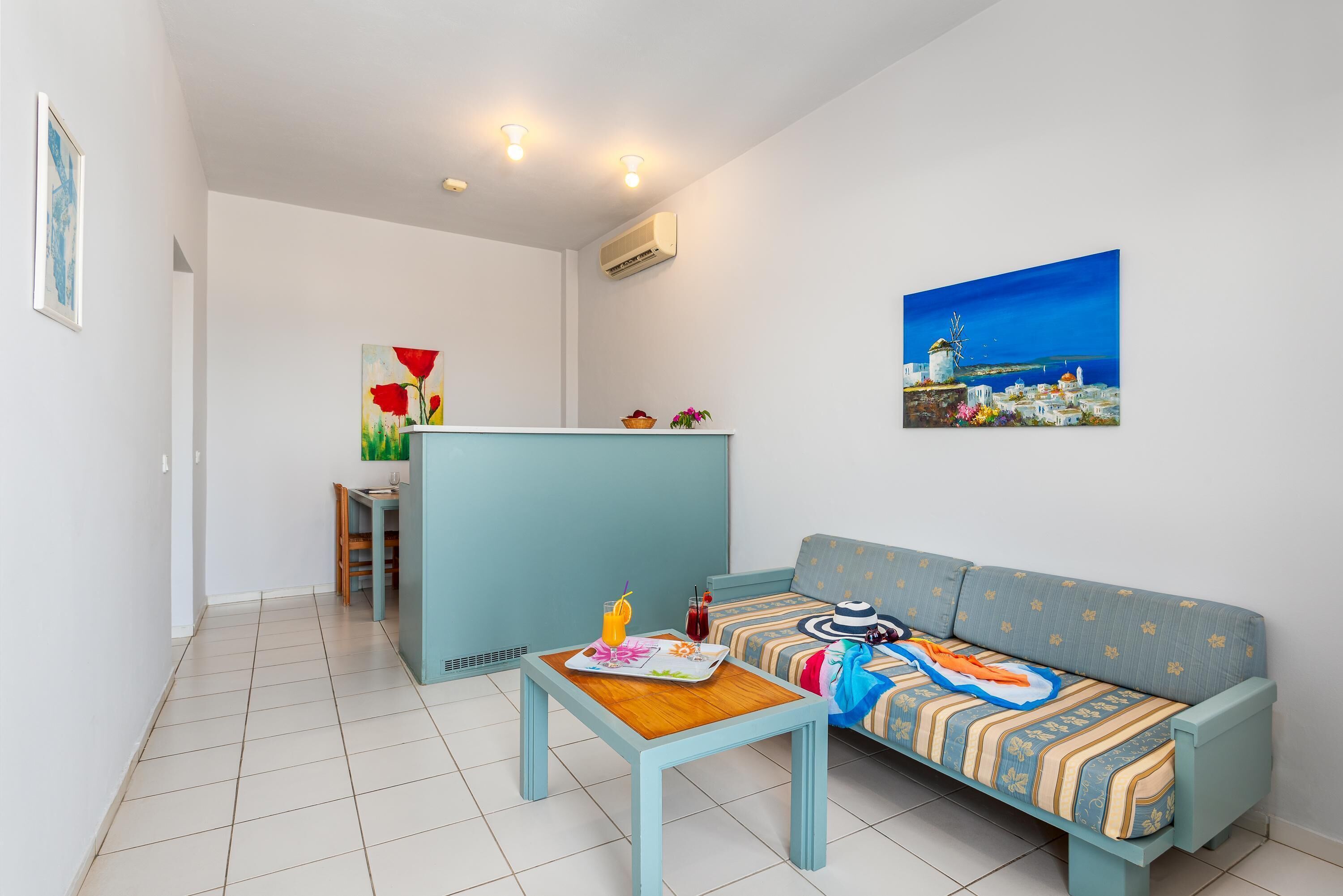 Ein Wohnzimmer mit einer Couch, einem Couchtisch und einem Gemälde einer Küstenlandschaft.