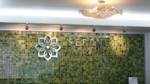 A reception area with a mosaic wall and a chandelier. - Serene Residence (Kanchanaburi)
