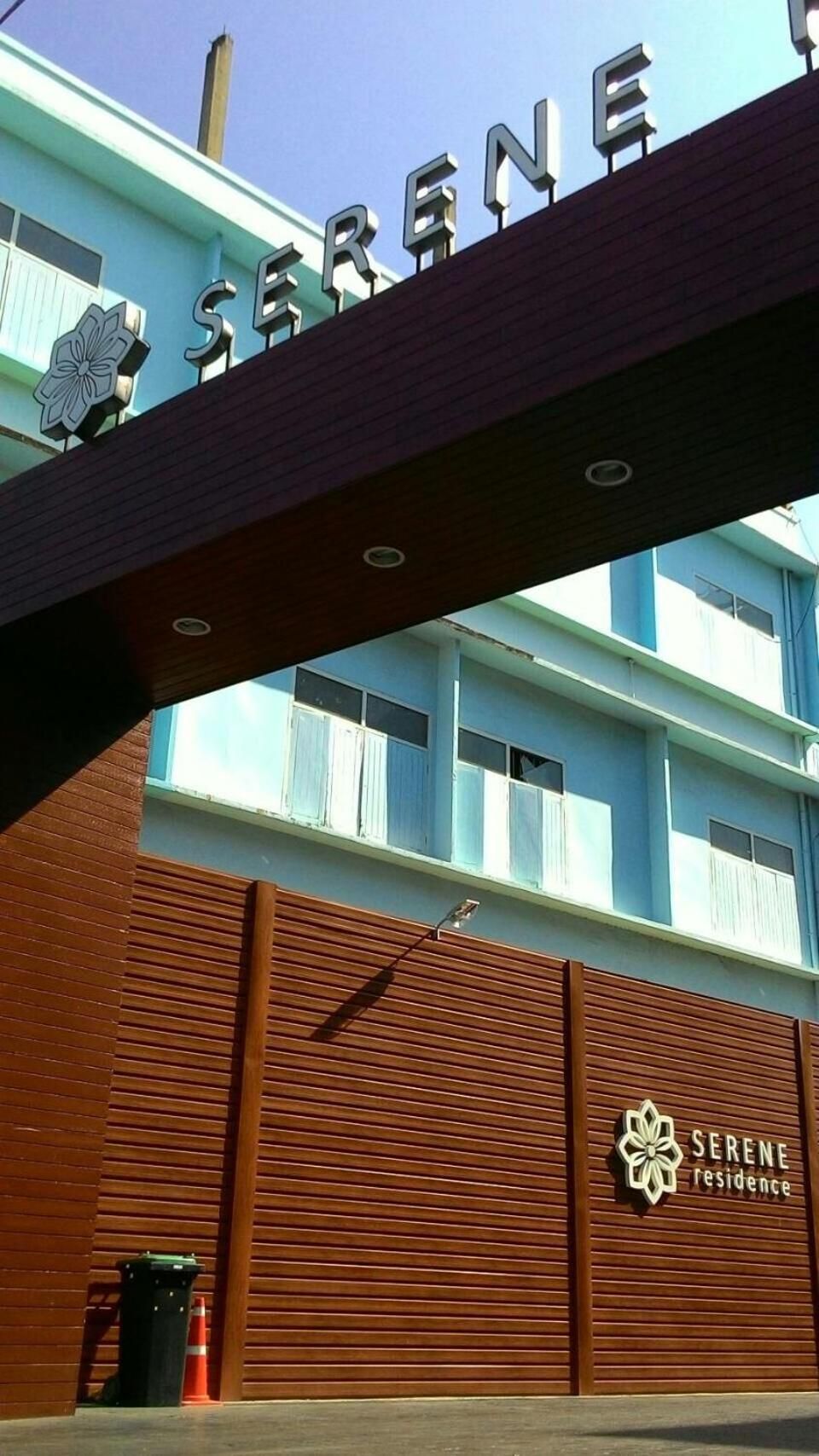 Een gebouw met de naam 'SERENE Residence' op de gevel, uitgevoerd in moderne architectuur met een plat dak en grote ramen.