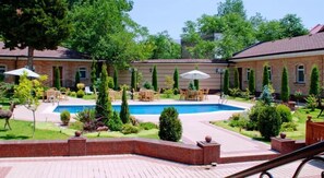Piscine extérieure en saison, parasols, chaises longues