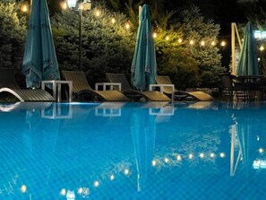 季节性开放的室外游泳池，池畔遮阳伞，日光浴躺椅