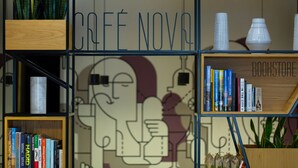 A bookstore with shelves of books and a wall with a graphic design. - Nova Hotel Yerevan (Yerevan)