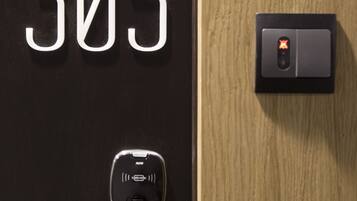 A door with the number 305, a keyhole, a door handle, and a modern electronic lock.