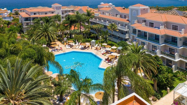 A resort with a central swimming pool surrounded by palm trees and sun loungers. - Hotel Riu Garoé (Puerto de la Cruz)
