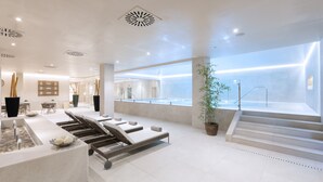 A modern spa area with a pool, lounge chairs, and a staircase leading to an upper level. - Hotel Riu Garoé (Puerto de la Cruz)