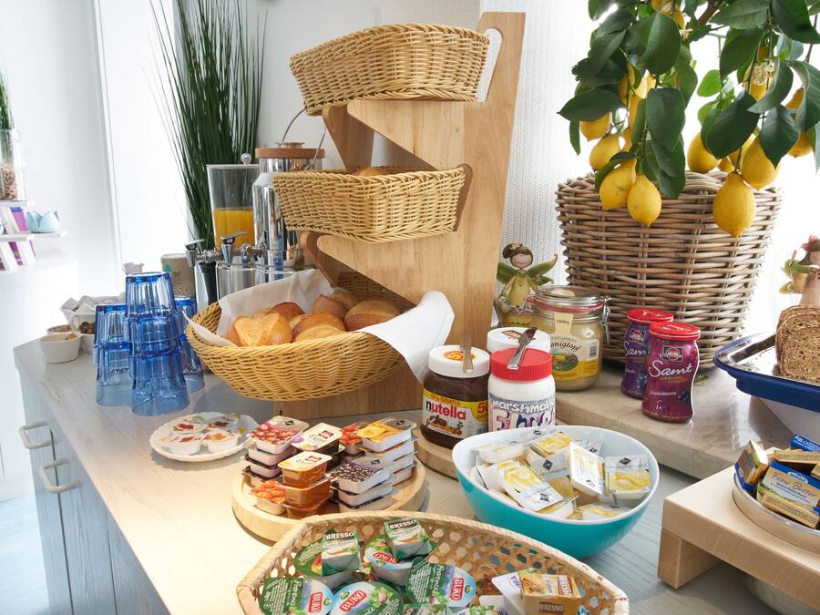 En morgenmadsbuffet med forskellige retter, kurve og glas med pålæg.