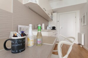 A modern kitchen with a countertop, a coffee machine, and a refrigerator.