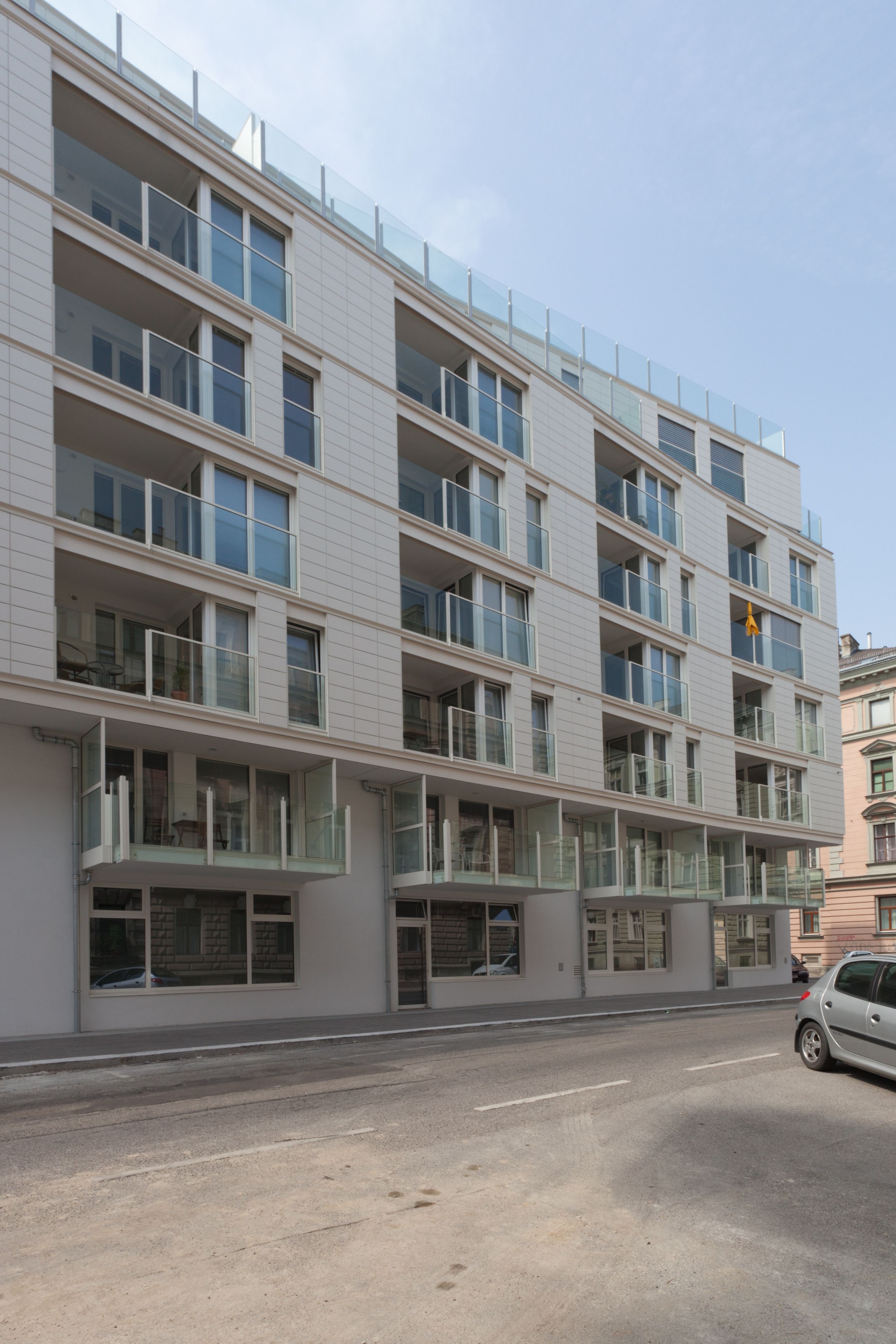 Um edifício moderno de vários andares com varandas e grandes janelas.