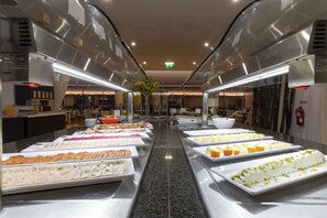 Un buffet con diversi cibi disposti su vassoi.