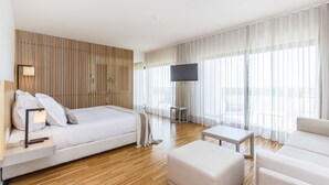 Een moderne hotelkamer met een groot bed, een bureau, een stoel en een televisie.