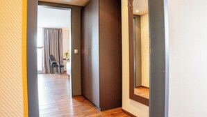 Ein Flur mit Holzboden, einem großen Kleiderschrank und einem Spiegel an der Wand.