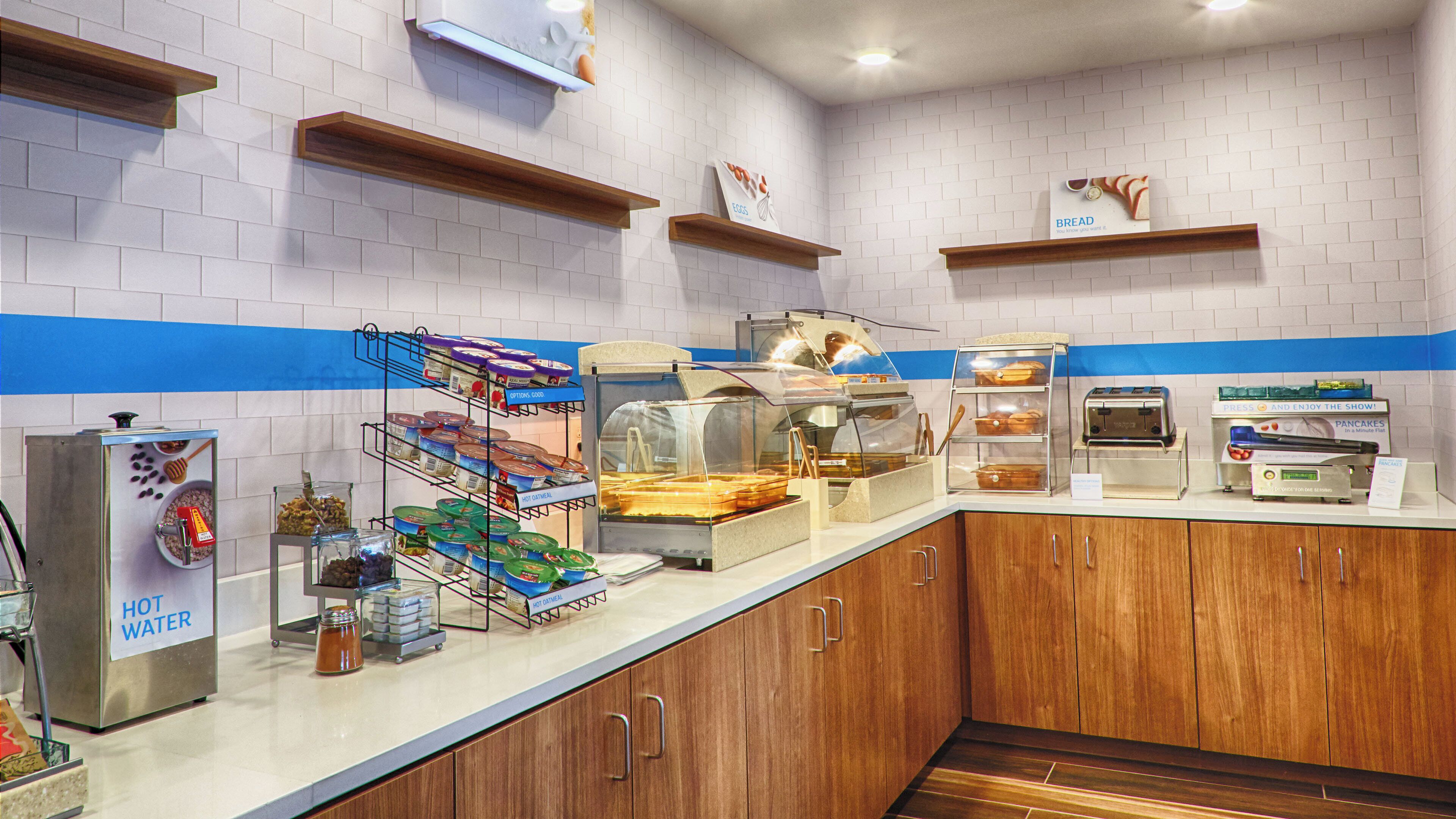 A breakfast buffet with various food options, including hot water, oatmeal, and hot cereal.