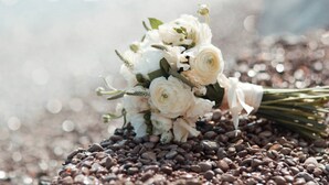 Un ramo de flores blancas sobre una cama de granos de café.