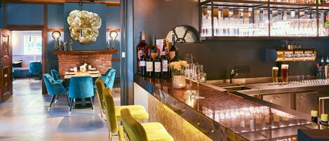 Un espace bar comprenant un comptoir, des tabourets de bar et une variété de bouteilles et de verres.
