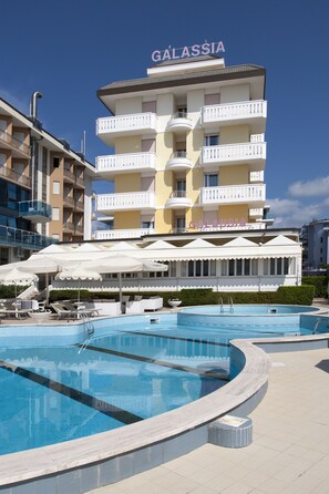 A hotel named Galassia with a swimming pool area, multiple balconies, and outdoor seating. - Hotel Galassia (Jesolo)