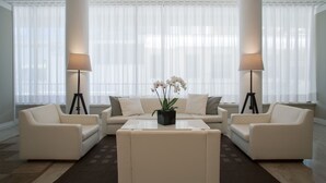 A modern living room with a sofa set, a coffee table, and two floor lamps. - Hotel Galassia (Jesolo)