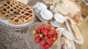 A buffet table with various food items including pies, strawberries, and pastries. - Hotel Galassia (Jesolo)