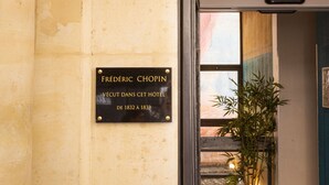 A historical hotel entrance with a plaque, a lantern, and a potted plant. - Hôtel Victoria Paris (Paris)