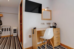 A hotel room with a wooden desk, a white chair, a flat-screen TV mounted on the wall, a wooden-framed mirror, and a coffee maker on the desk. - Lothersdale Hotel Morecambe by Belvilla (Morecambe)