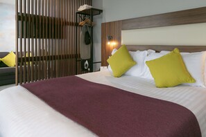 A hotel room with a large bed, a wooden headboard, and a wardrobe with hanging clothes. - Best Western Lancaster Morecambe Lothersdale Hotel (Morecambe)