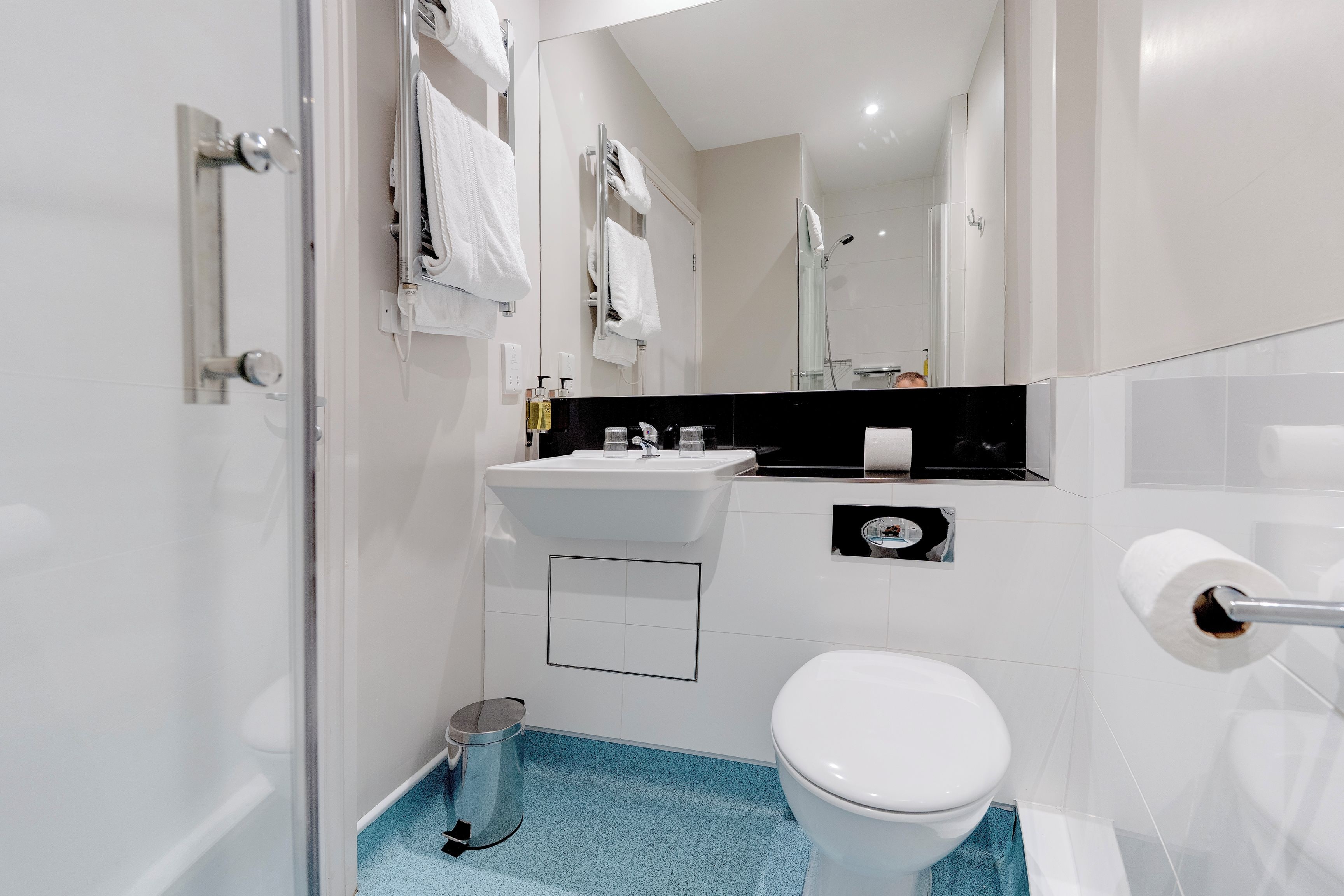 Un baño moderno con inodoro, lavabo y ducha.