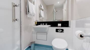 Un baño moderno con inodoro, lavabo y ducha.