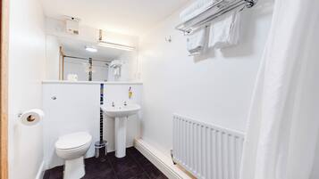 A small, clean bathroom with a toilet, sink, and towel rack.