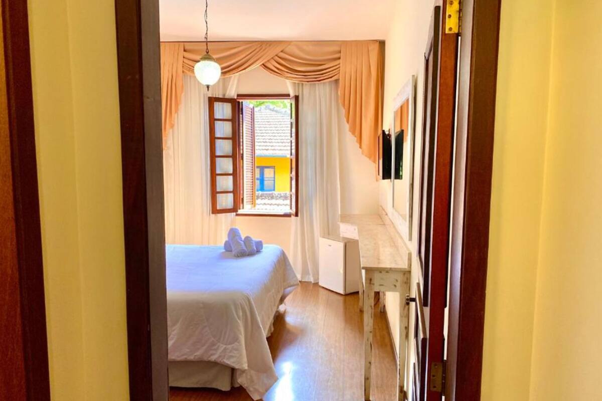 Una habitación de hotel con cama, escritorio y vistas al exterior.