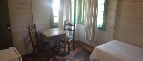 Una habitación con dos camas, una mesa y una silla.