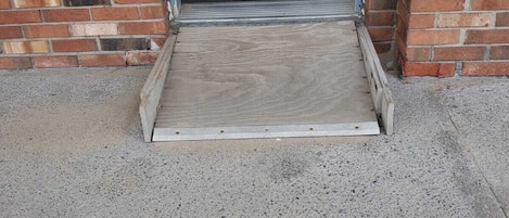 A doorway with a wooden ramp leading to a brick building.