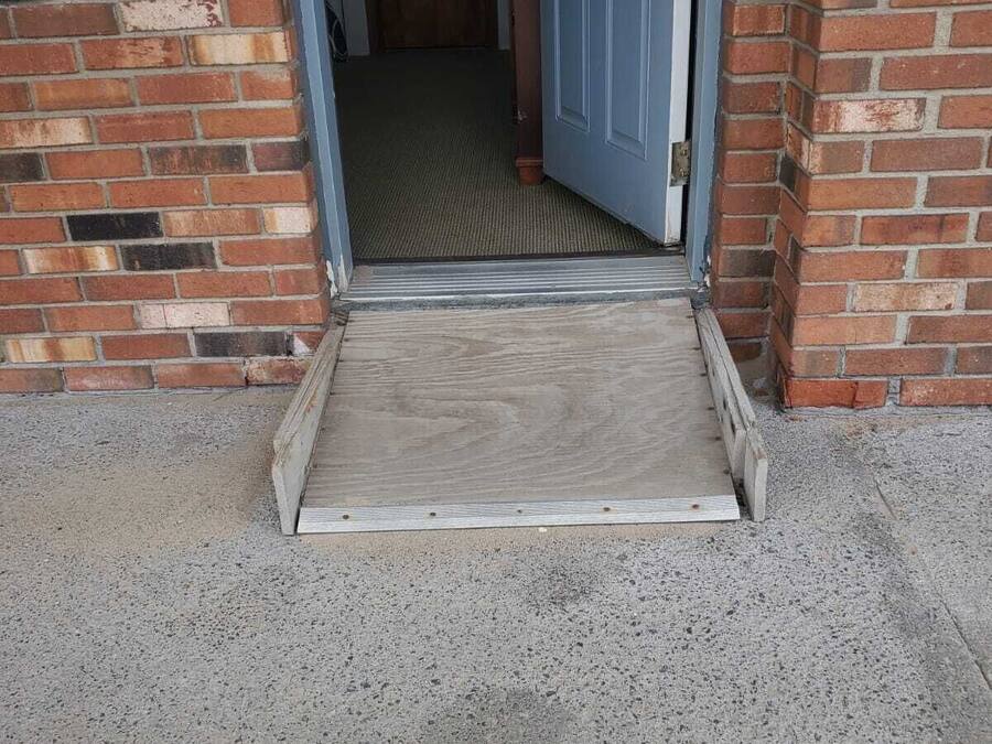 Una puerta con una rampa de madera que conduce a un edificio de ladrillo.