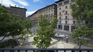 A street view with buildings, trees, and a clear sky.