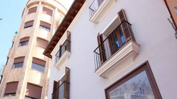 Um edifício de vários andares com varandas e uma grande janela com o texto "mas Bosch".