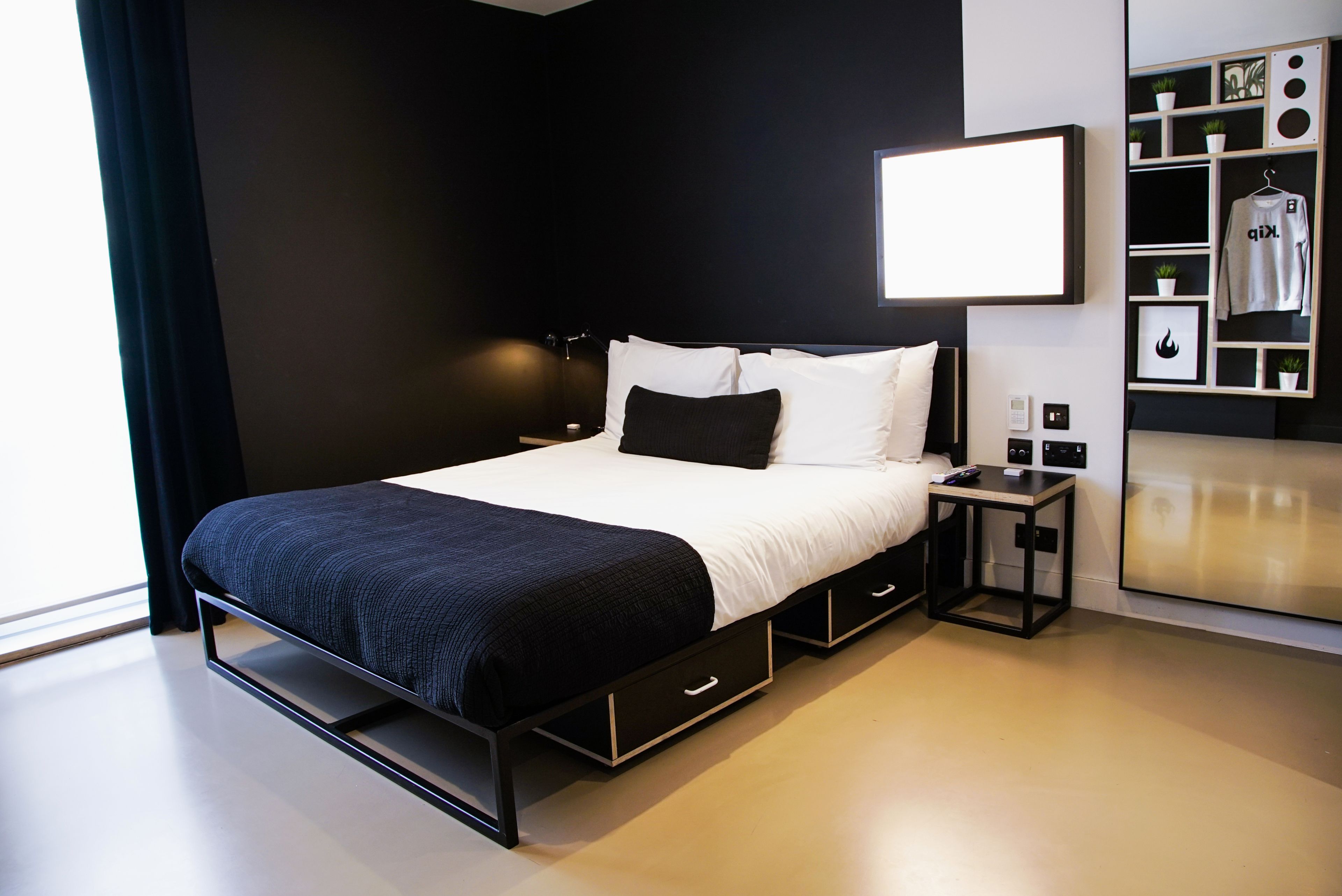A modern bedroom with a bed, bedside tables, and a built-in wardrobe.