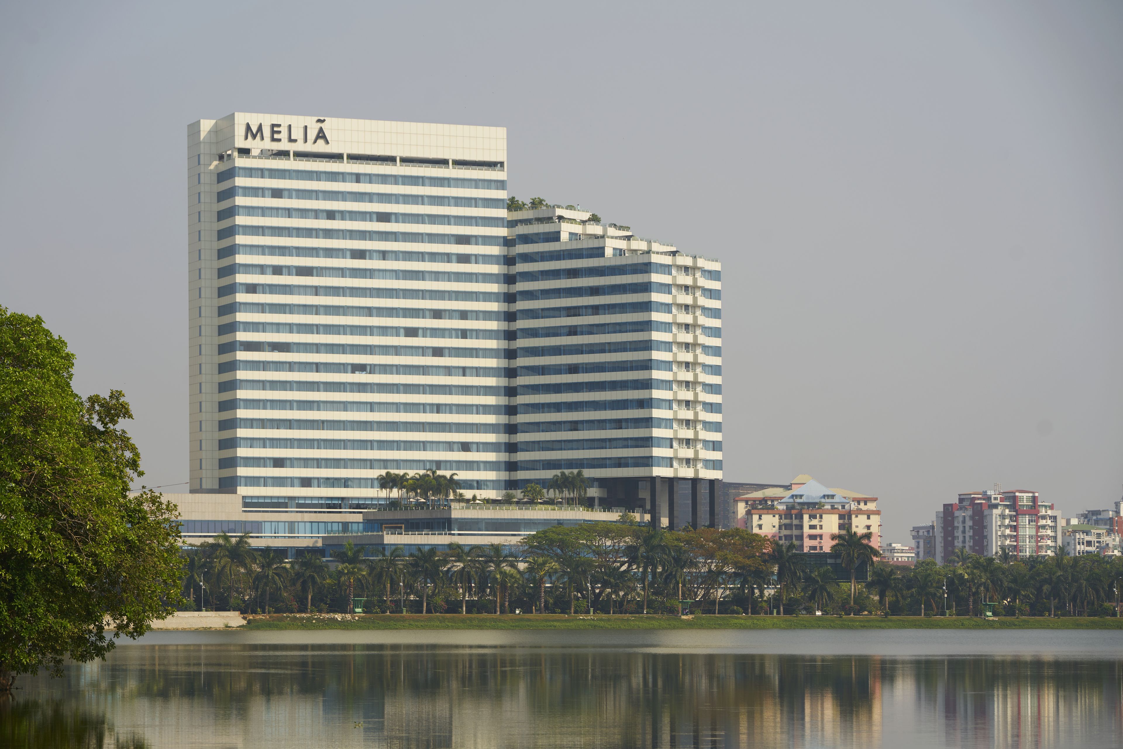 A high-rise hotel with a modern design, featuring a prominent "MELIA" sign at the top.