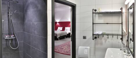 A modern bathroom with a shower, a sink, and a mirror.