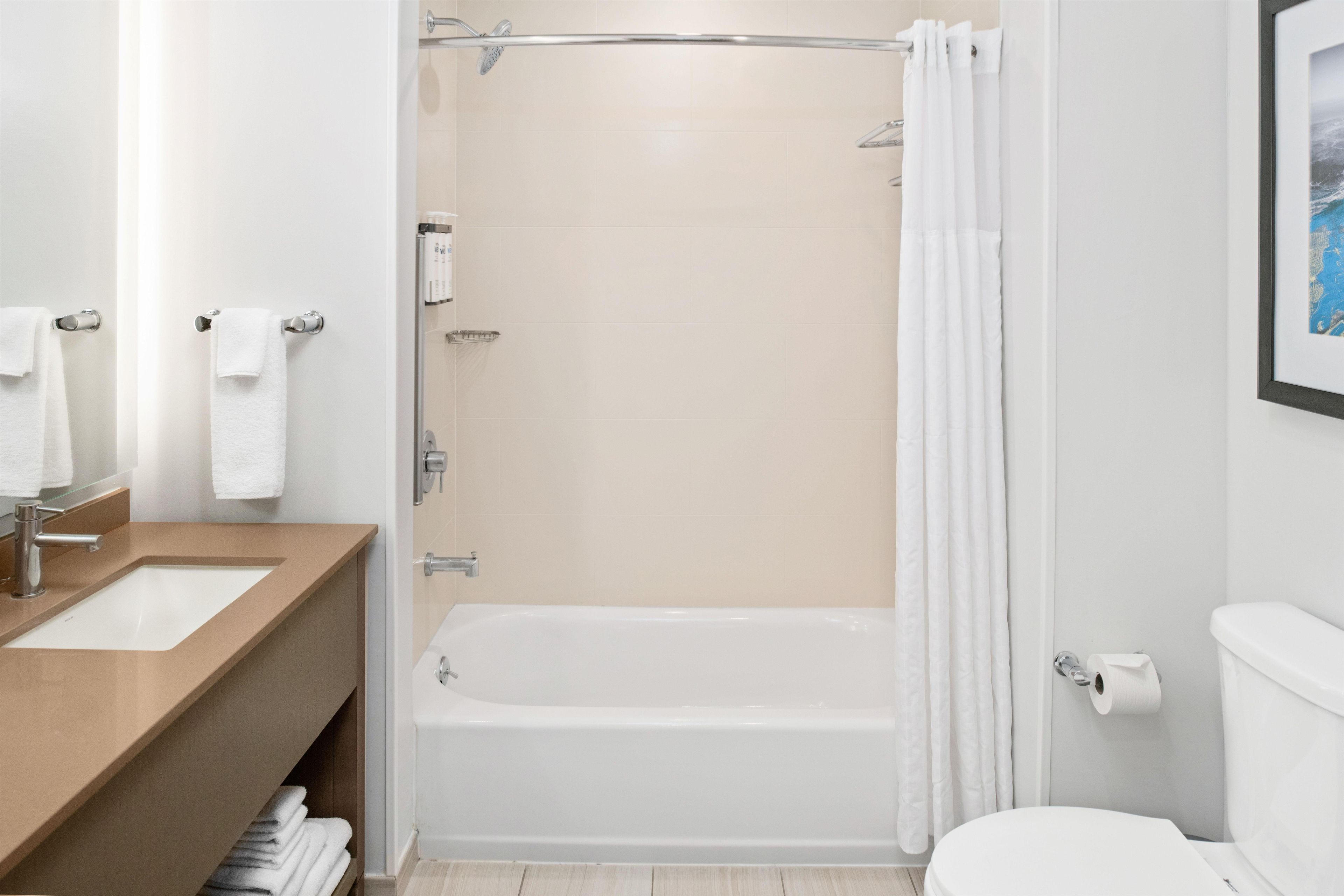 A modern bathroom with a bathtub, toilet, and sink.