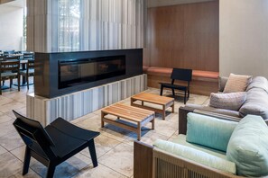 Una sala moderna con televisor de pantalla plana, muebles de madera y un sofá con cojines.