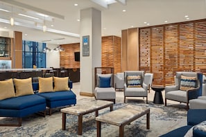 Un espace de détente moderne avec des canapés, des fauteuils et un bar.