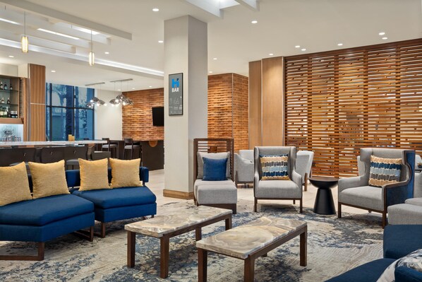 A modern lounge area with sofas, armchairs, and a bar. - Hyatt House at Anaheim Resort/Convention Center (Anaheim)