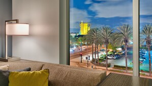 A modern hotel room with a large window, a sofa, and a lamp. - Hyatt House at Anaheim Resort/Convention Center (Anaheim)