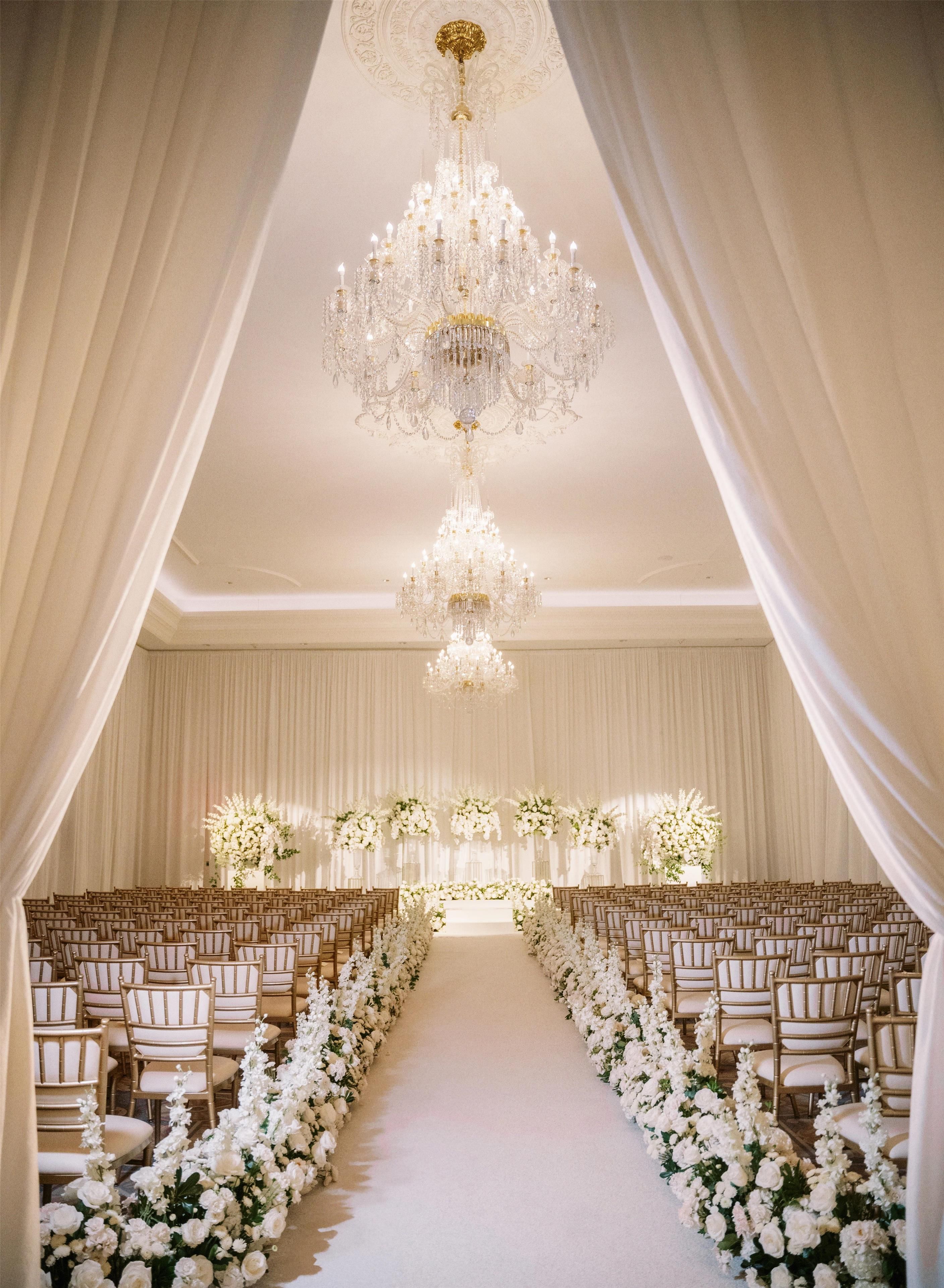 An aisle with rows of chairs and a floral arrangement at the end.