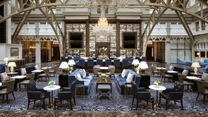 A spacious lobby with a grand chandelier, multiple seating areas, and a bar. - Waldorf Astoria Washington DC (Washington)